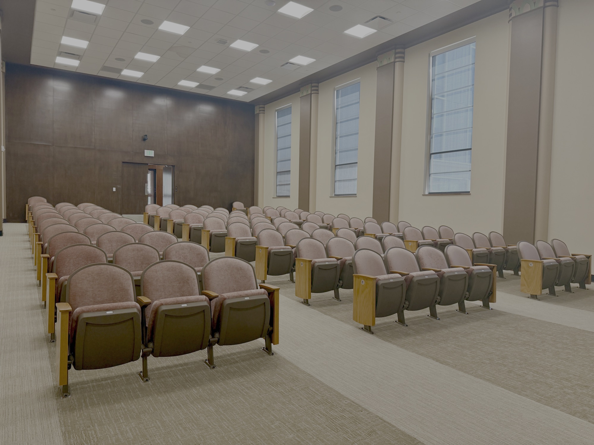 Auditorium at 1141 N Robinson: rows of fixed seating beneath the restored Art Deco ceiling