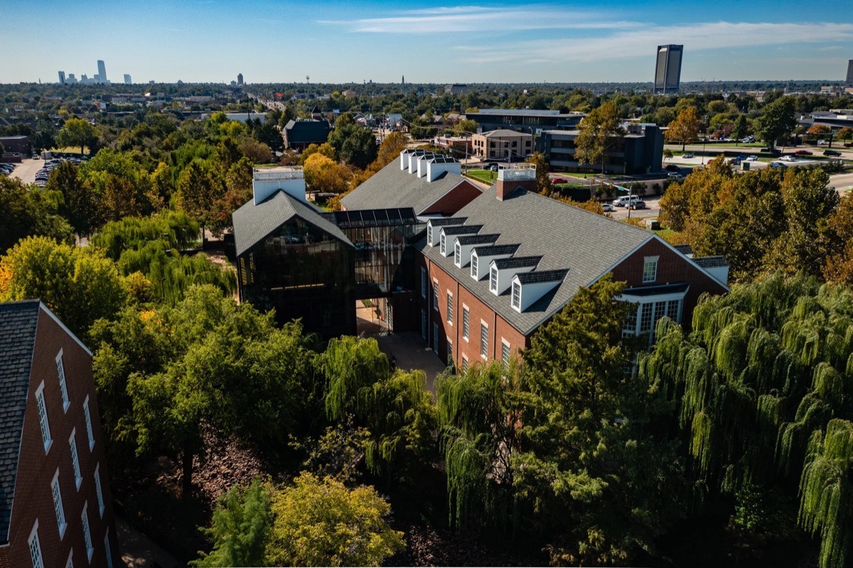 Aerial view of The Peake campus — glass building beside brick collegiate-style buildings, Oklahoma City