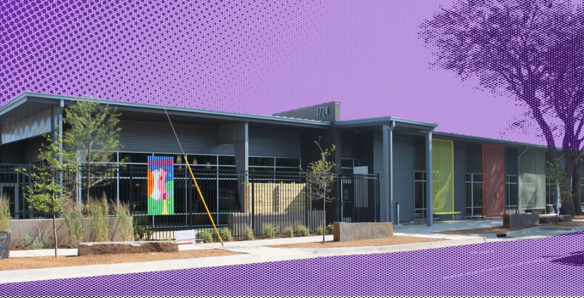 The WestTown Homeless Resource Campus at 1724 NW 4th in Oklahoma City — corrugated metal walls, colored entry panels, and community art on the perimeter fence