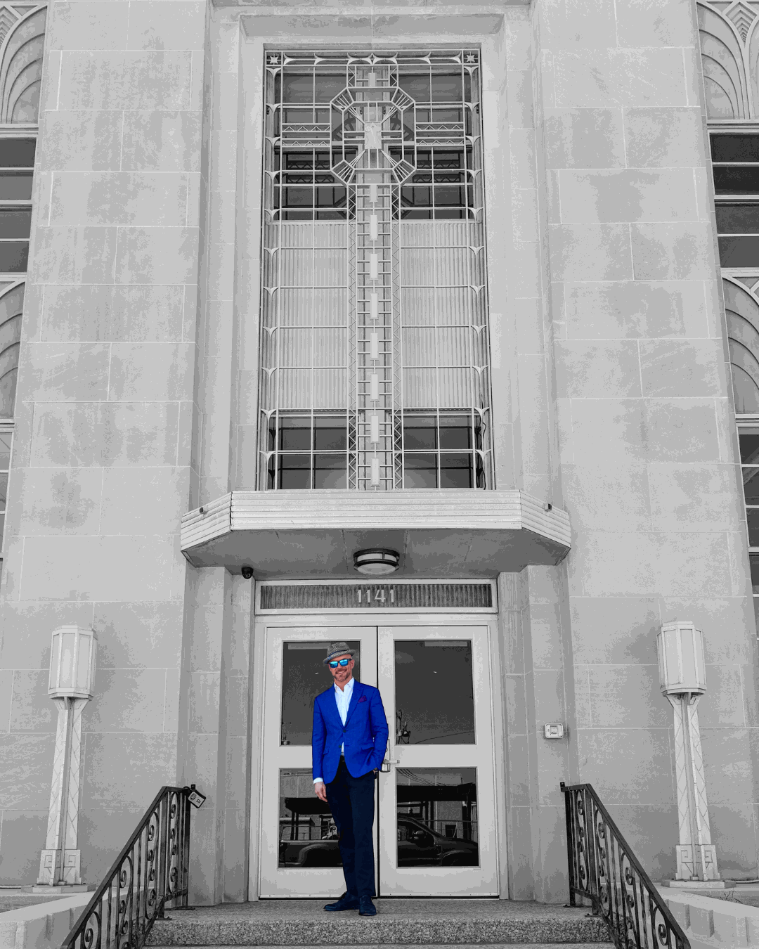 Aaron Diehl in a blue blazer in front of the Art Deco entrance of 1141