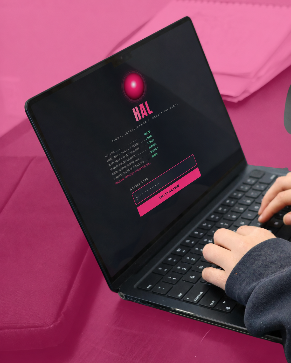 HAL running on a laptop against an HTD pink background